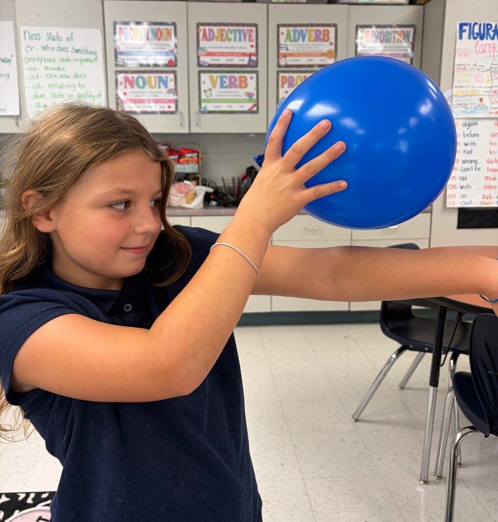 A girl holding a balloon over her arm to display static electricity