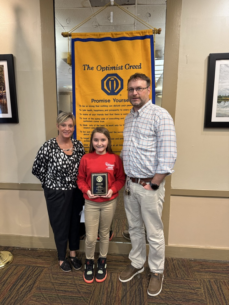 our September Optimist award winner Karlee holding her plaque with her mom and principal Roberston