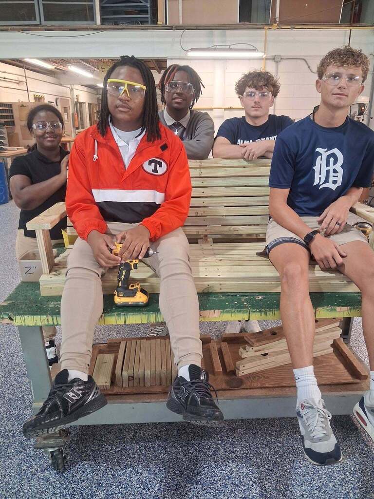 Bryant Career Teach students sitting on a wooden swing they constructed.