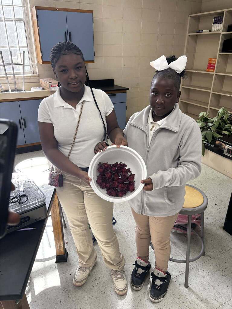 Two students holding a bucket of berries