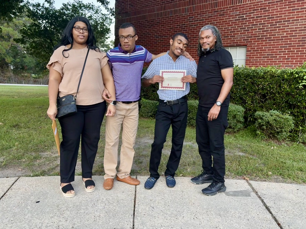 Sam with his family holding his certificate 