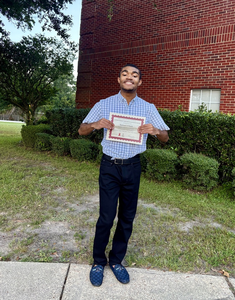 Sam holding his red ribbon week certificate 