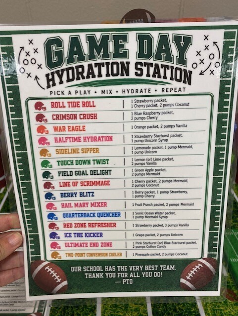A colorful sign with a football field graphic lists hydration station drink options. It includes football-themed names such as "War Eagle Hydration" and "Touchdown Twist."