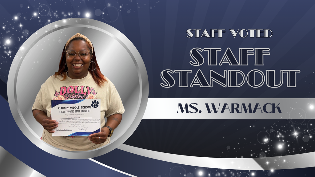 Person in yellow shirt holds certificate labeled "Staff Standout" with "Ms. Warnock" written below.