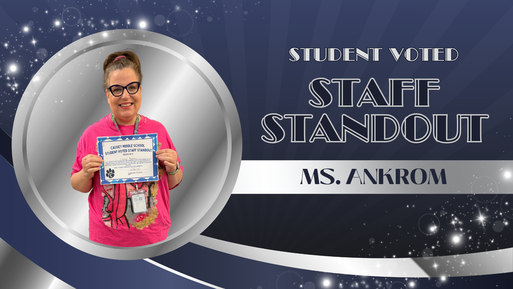 A person wearing glasses and a pink shirt holds a certificate with "Ms. Ankrom" on it.