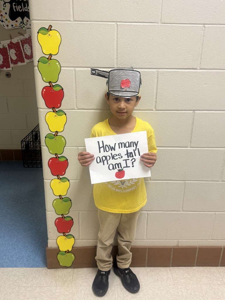 A child in a yellow shirt holds a sign with math question "How many apples tall am I?".