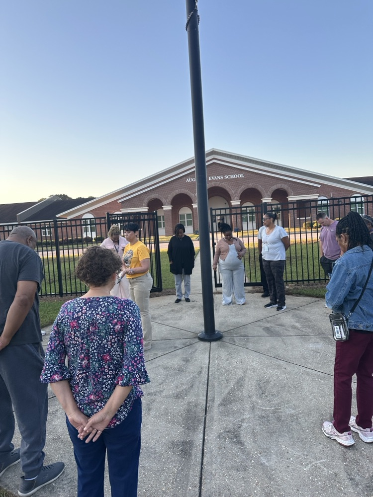 Mrs Kidd giving a word of encouragement to her staff around the flagpole 