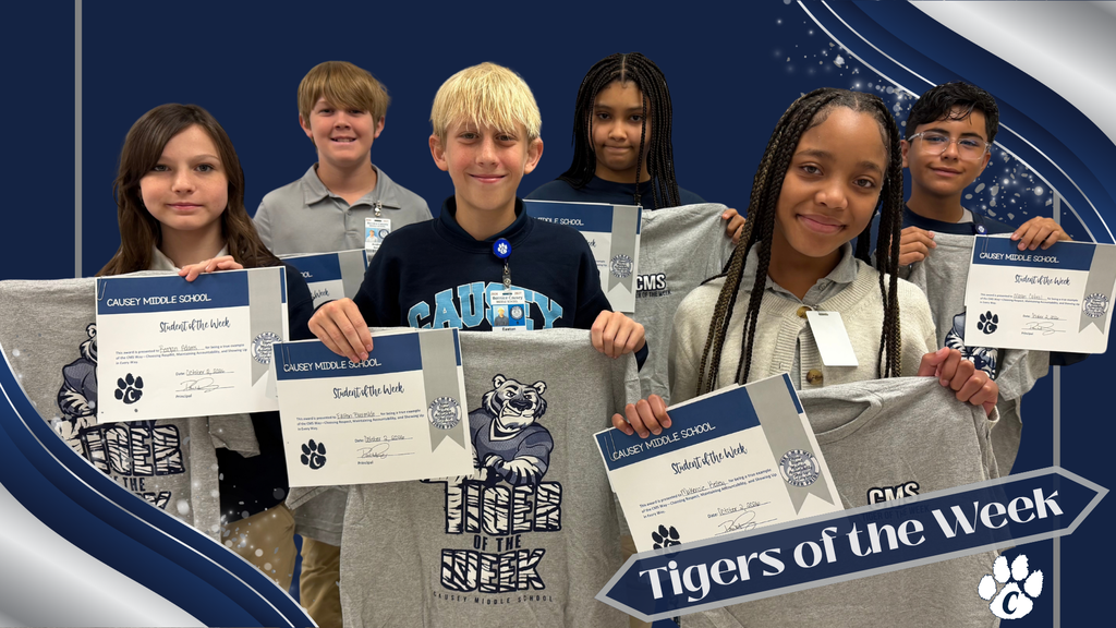 Kids hold up shirts and certificates. One shirt says "Tigers of the Week" in blue.