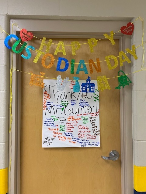 A door with a yellow banner reading "Happy Custodian Day" and a white paper with a message attached.