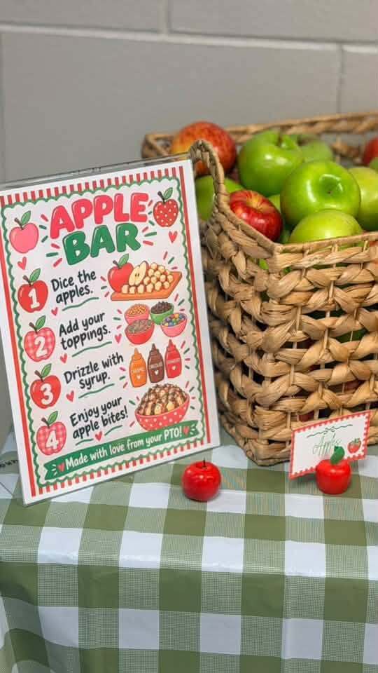 A table with a basket of apples and an apple bar sign next to it. The sign lists the steps for creating an apple bar.