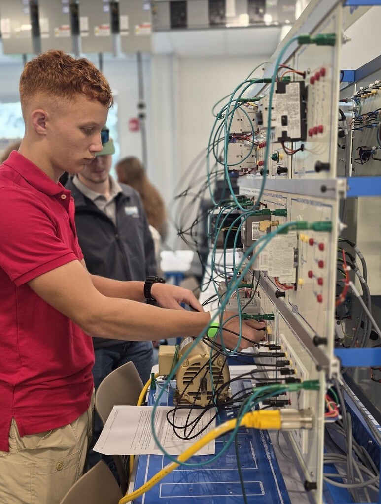 A student works at a board full of wiring