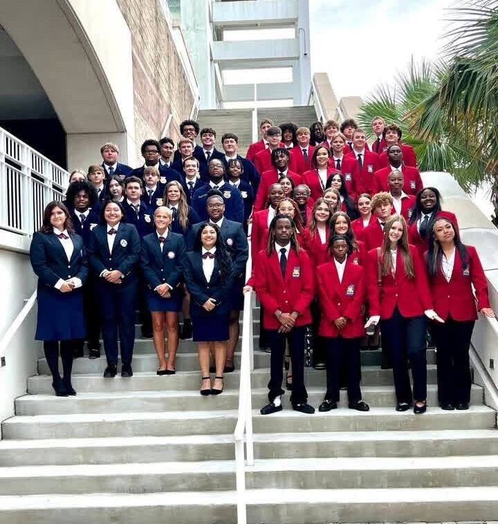 Students in red and blue blazers standing on the steps of the Mobile Convention Center