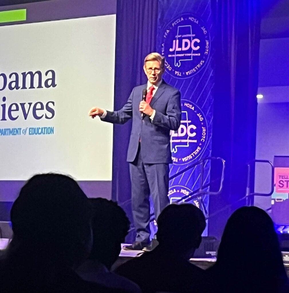 Dr. Eric Mackey speaks on a stage