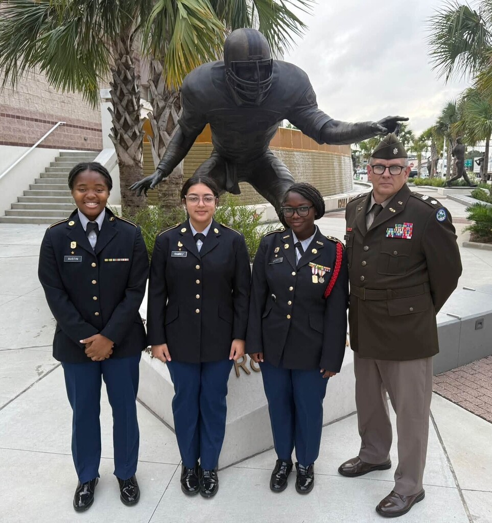 A JROTC instructor in uniform and three cadets
