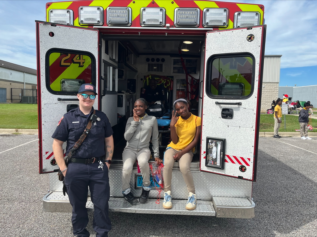 A paramedic and two students at the back of an ambulance