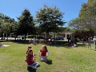 students and parents eating a picnic lunch