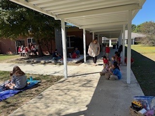 students and parents eating a picnic lunch