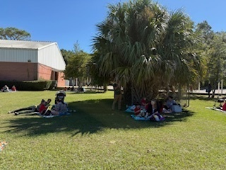 students and parents eating a picnic lunch