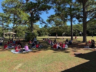 students and parents eating a picnic lunch