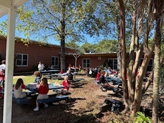 students and parents eating a picnic lunch