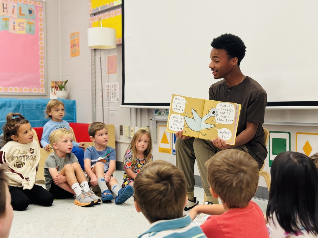 high schooler reading to preschoolers