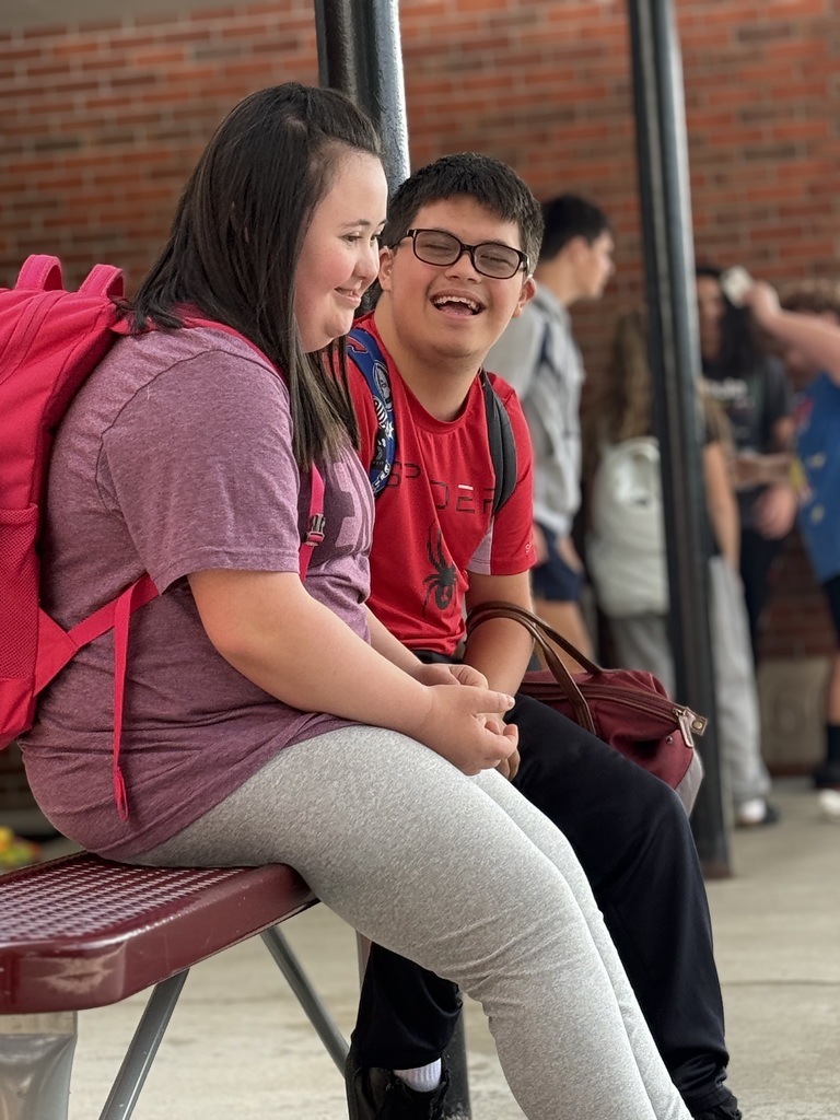 two students laughing on bench