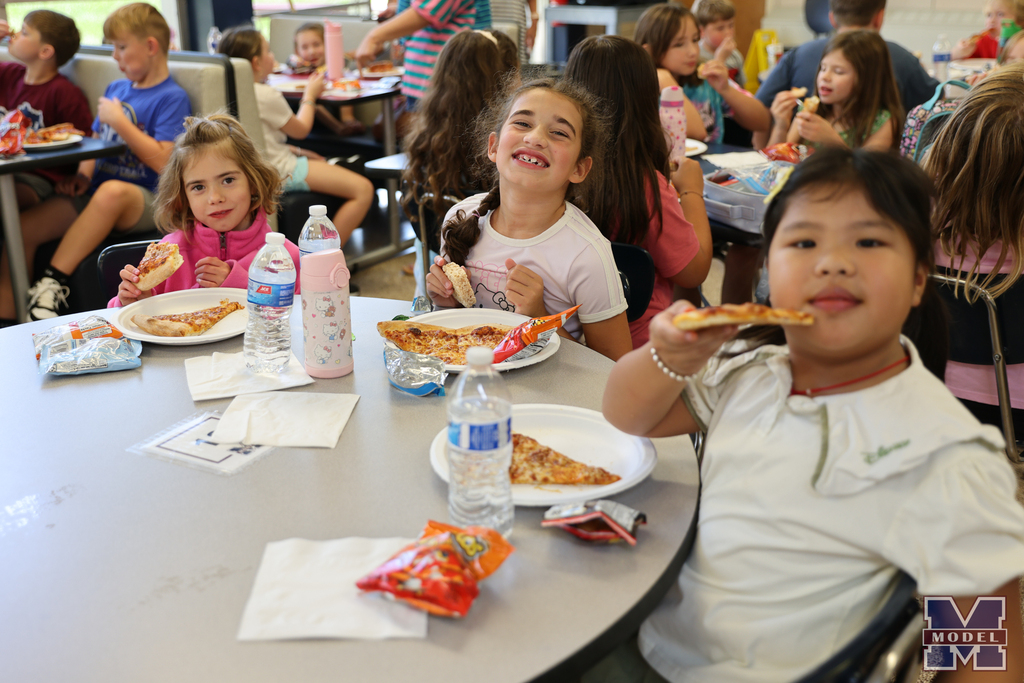 girls eating pizza and smiling