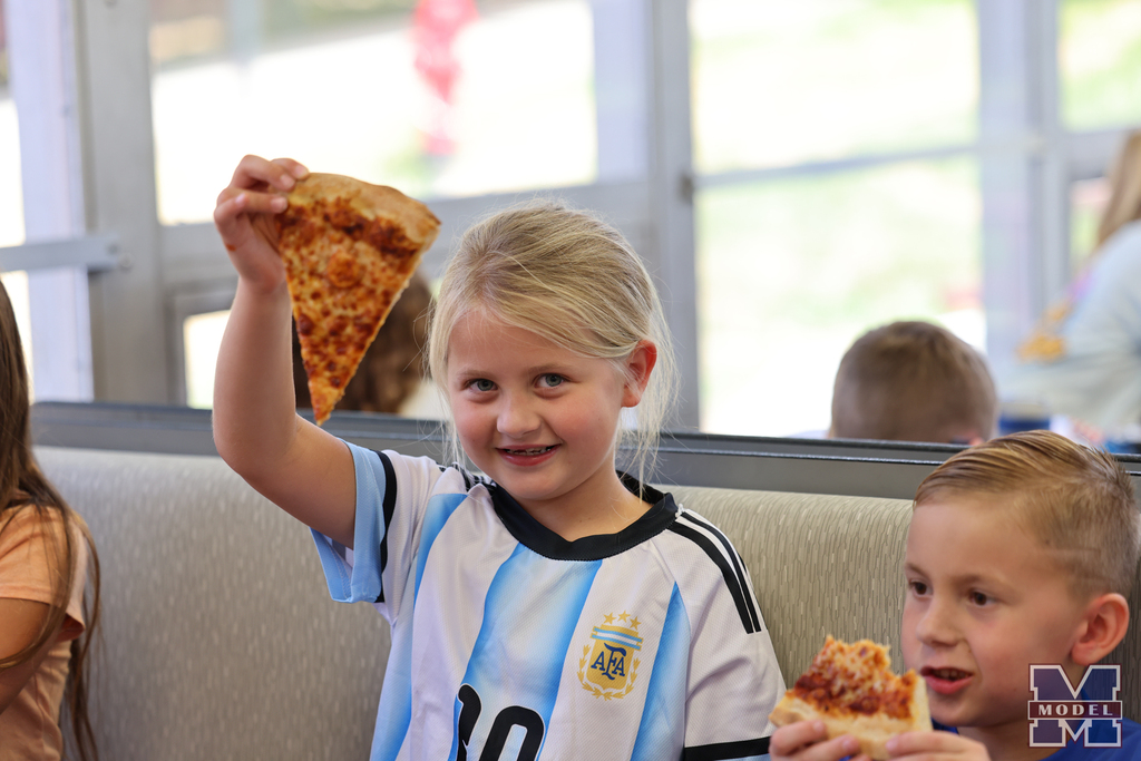 girl holding up pizza