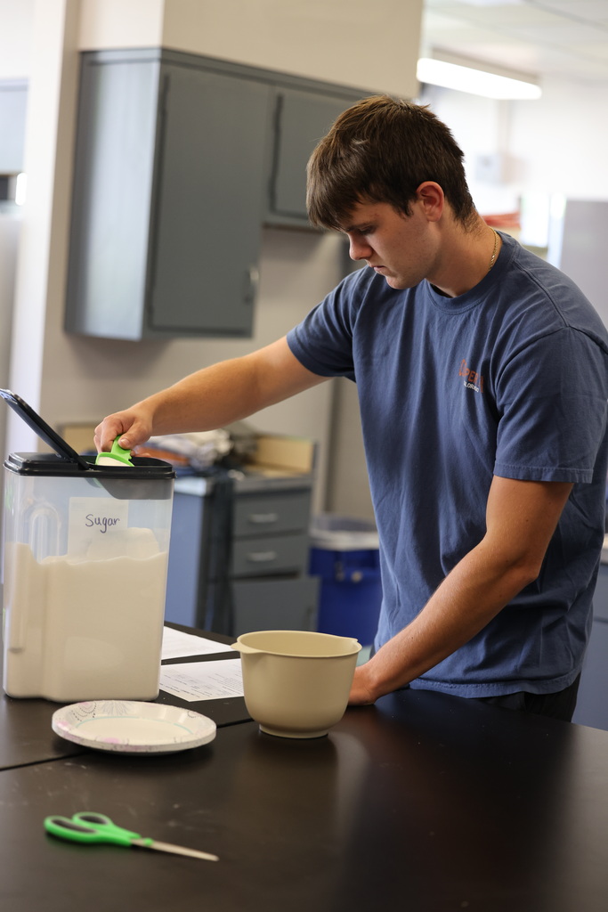student measuring sugar