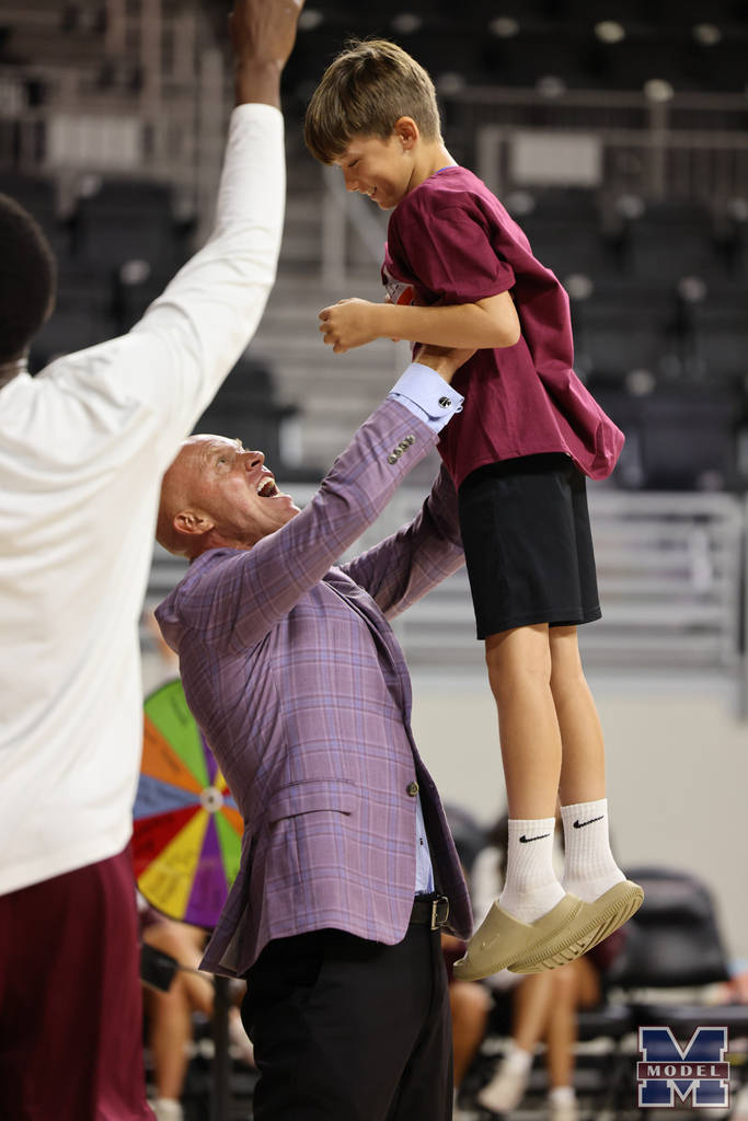 student picked up in the air by coach