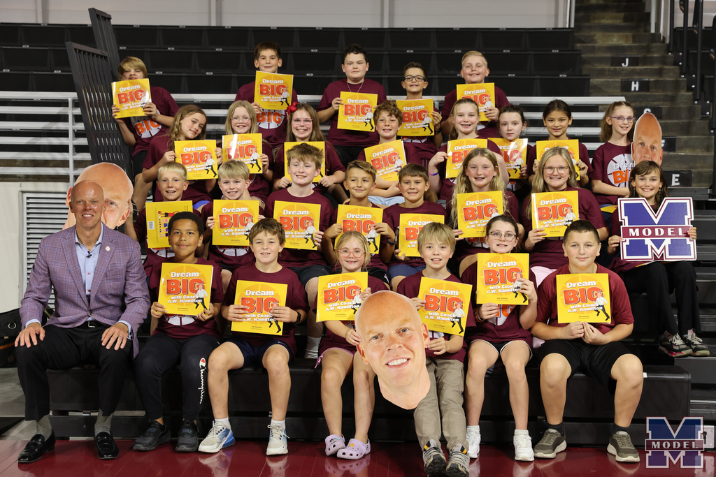 students posing with Coach Hamilton all holding his new book
