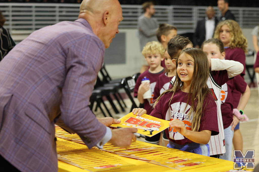 smiling student receiving book