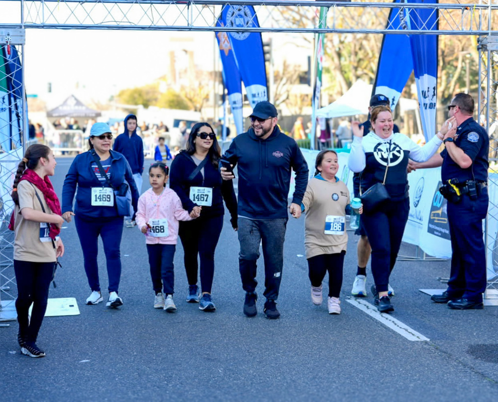 Families cross the finishline at "10k With a Cop' in Downtown Modesto