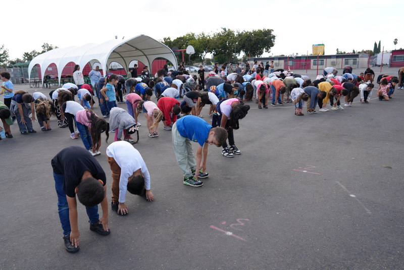 Rob Road students touch their toes in a stretch to gear up for a Friday fun run.