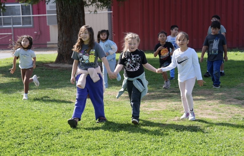 Students hold hands as they cross the finish line at Rob Road Elementary School.