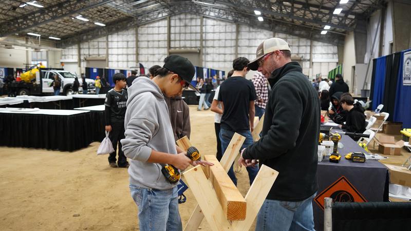 A Construction CTE Teacher and student engage in a hands-on activity at the Expo.