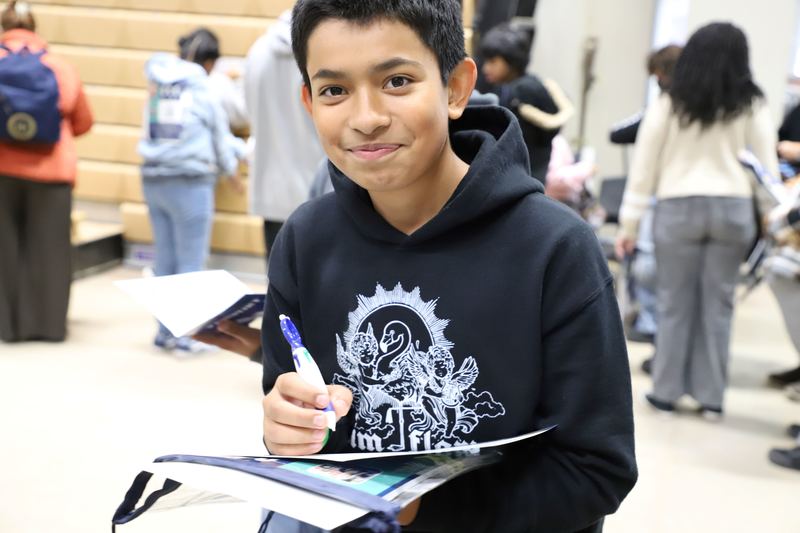 Eight grade student filling out his passport card to turn in for a prize.