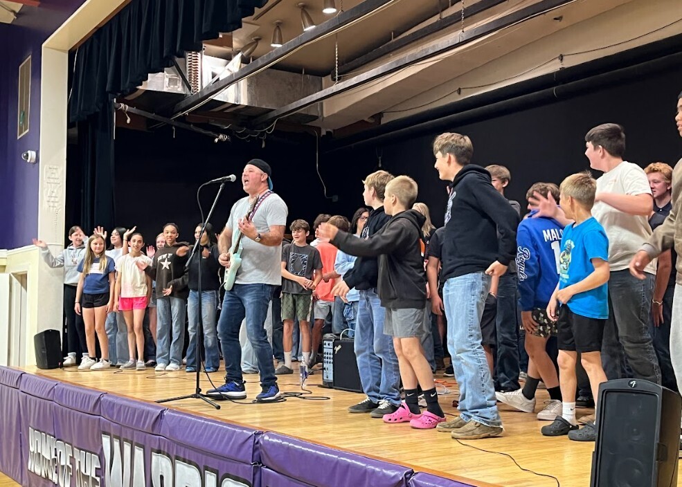 Performer and students on stage