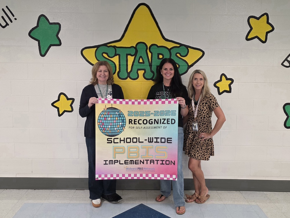 principals and teachers with a banner