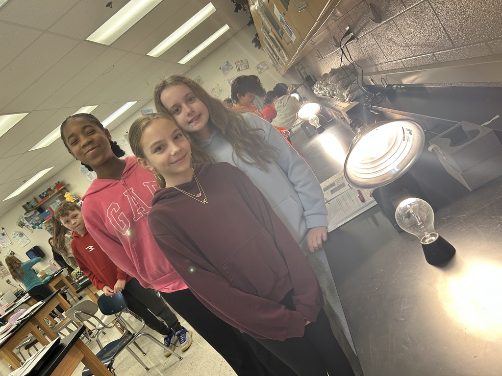 6th graders investigating direct and indirect sunlight with lamp