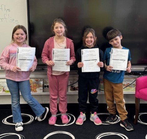 2nd graders with their information writing books