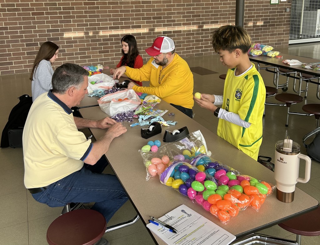 volunteers putting candy in easter eggs
