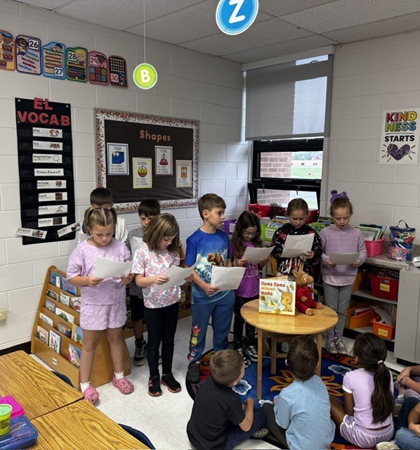 second grade students reading to kindergarten students