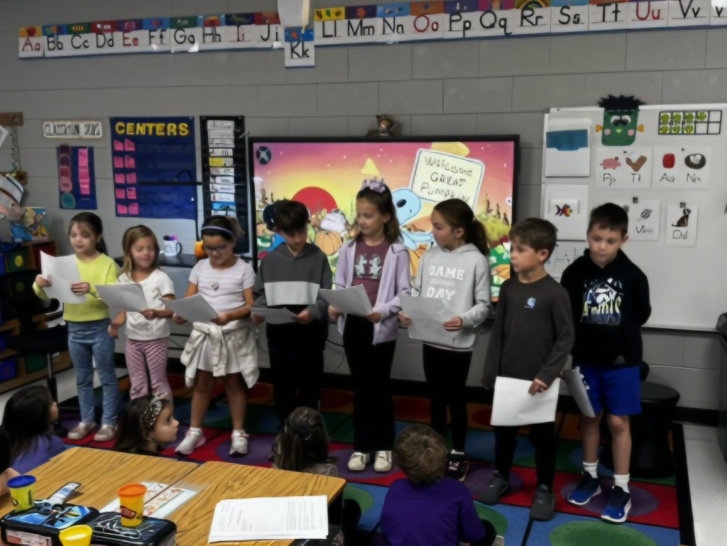 second grade students reading to kindergarten students
