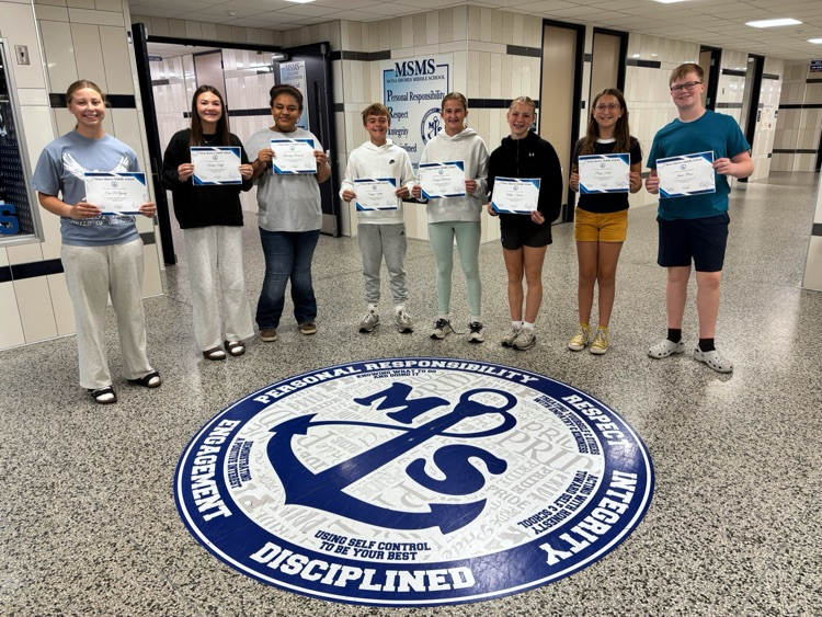 students in the foyer around our PBIS anchor with Sailor PRIDE components, holding their student of the month certificates