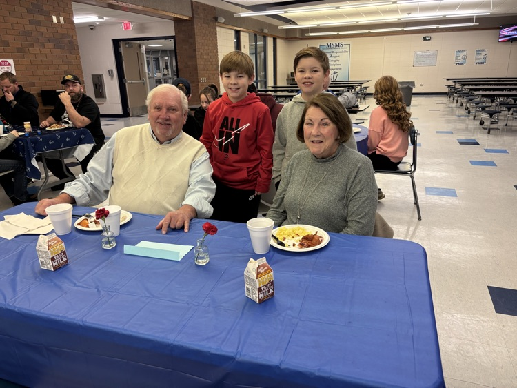 two boys and their grandparents at breakfast