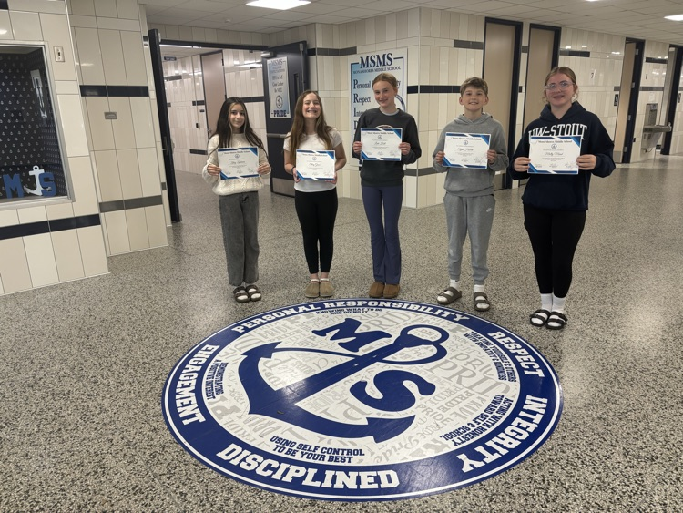 students of the month in the lobby with their certificates