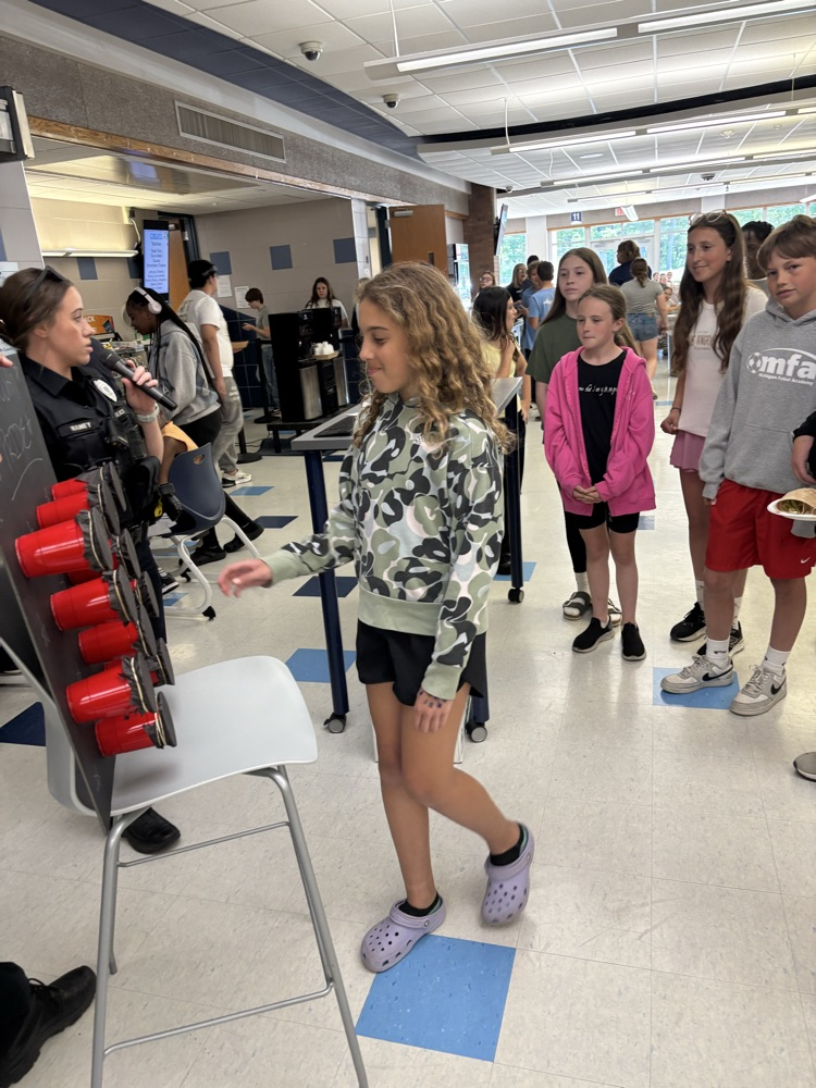 student participating in the cup game in the cafeteria