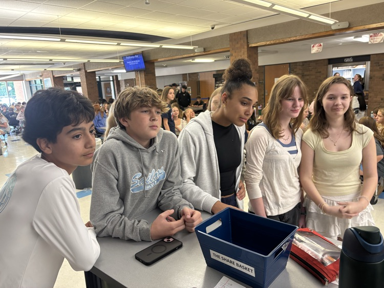 students around a table at lunch waiting their turn for ride with Pride game
