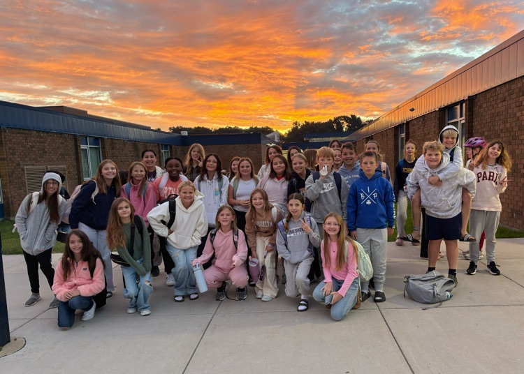 large group of 6th graders with the sunrise in the background 